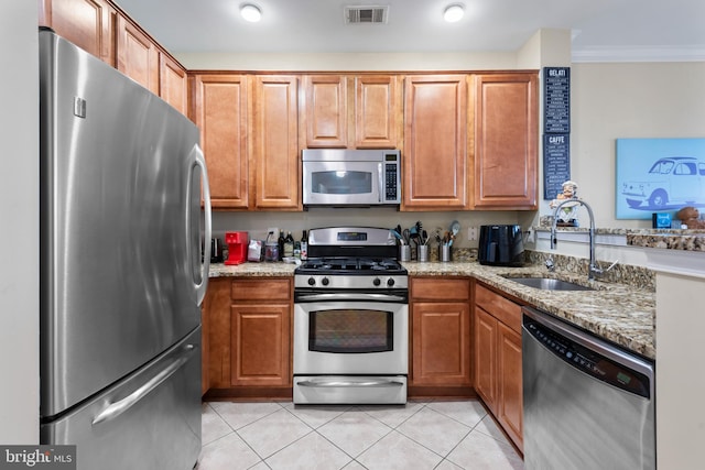 12000 Market St Unit 378, Reston, VA 20190 - kitchen with appliances with stainless steel finishes, crown molding, light stone countertops, light tile patterned flooring, and brown cabinets