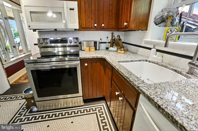 1722 Swamp Pike, Gilbertsville, PA 19525 - kitchen with white microwave, stainless steel electric stove, tasteful backsplash, and light stone countertops