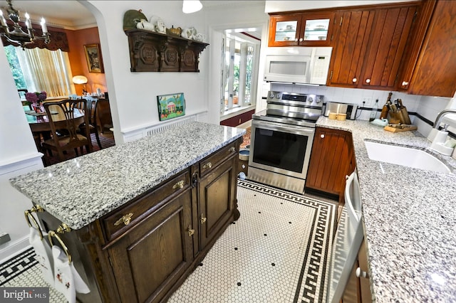 1722 Swamp Pike, Gilbertsville, PA 19525 - kitchen with white microwave, electric stove, a chandelier, arched walkways, and backsplash