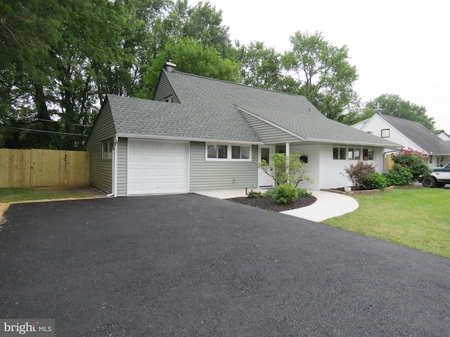 116 Hollow Rd, Levittown, PA 19056 - view of front facade featuring a garage, driveway, a shingled roof, and a chimney