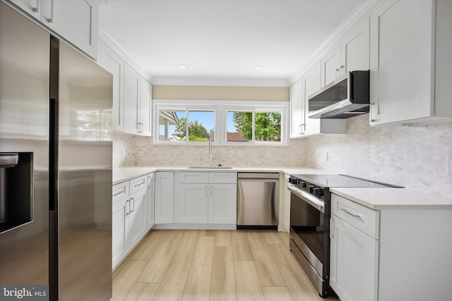 116 Hollow Rd, Levittown, PA 19056 - kitchen with stainless steel appliances, light wood-type flooring, white cabinetry, light countertops, and tasteful backsplash