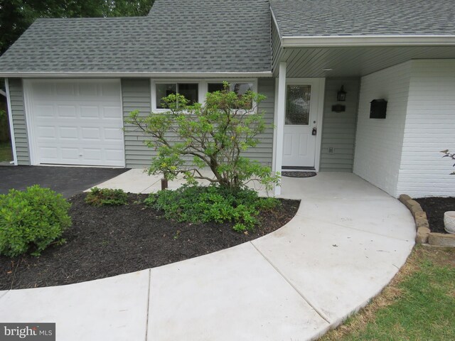 116 Hollow Rd, Levittown, PA 19056 - doorway to property featuring a shingled roof and an attached garage