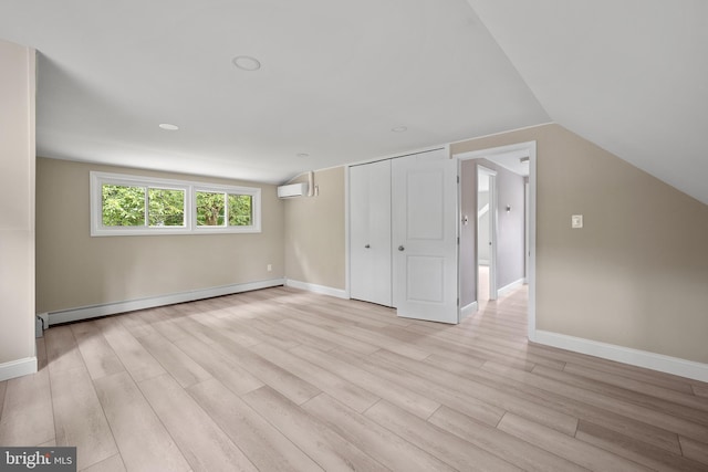 116 Hollow Rd, Levittown, PA 19056 - additional living space with a baseboard radiator, a wall mounted AC, light wood-style floors, and vaulted ceiling