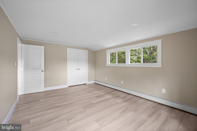 116 Hollow Rd, Levittown, PA 19056 - unfurnished bedroom featuring a baseboard heating unit, light wood-type flooring, a closet, and lofted ceiling