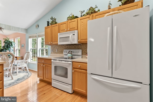 32618 Seaview Loop, Millsboro, DE 19966 - kitchen featuring white appliances, vaulted ceiling, tasteful backsplash, light wood-style floors, and light countertops