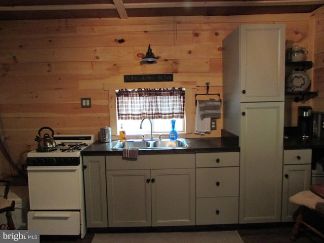 293 Snow Shoe Mountain Forest Rd, Snow Shoe, PA 16874 - kitchen with white gas range, wood walls, dark countertops, and white cabinetry
