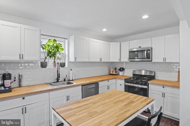 5117 Duel Pl, Capitol Heights, MD 20743 - kitchen with butcher block counters, appliances with stainless steel finishes, backsplash, white cabinetry, and recessed lighting