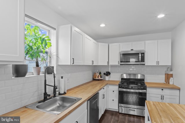 5117 Duel Pl, Capitol Heights, MD 20743 - kitchen with appliances with stainless steel finishes, butcher block countertops, tasteful backsplash, white cabinetry, and recessed lighting