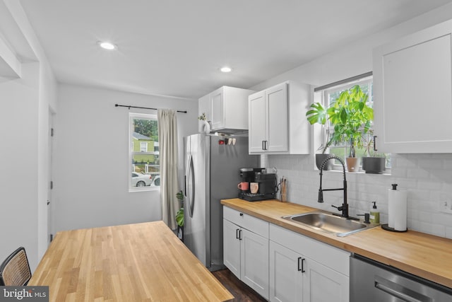 5117 Duel Pl, Capitol Heights, MD 20743 - kitchen with wooden counters, stainless steel appliances, decorative backsplash, white cabinets, and recessed lighting