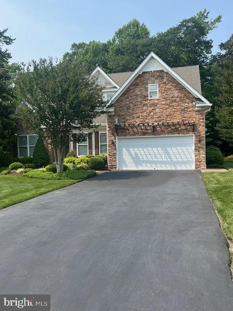 24872 Rivers Edge Rd, Millsboro, DE 19966 - view of front facade featuring asphalt driveway, stone siding, an attached garage, and a front lawn
