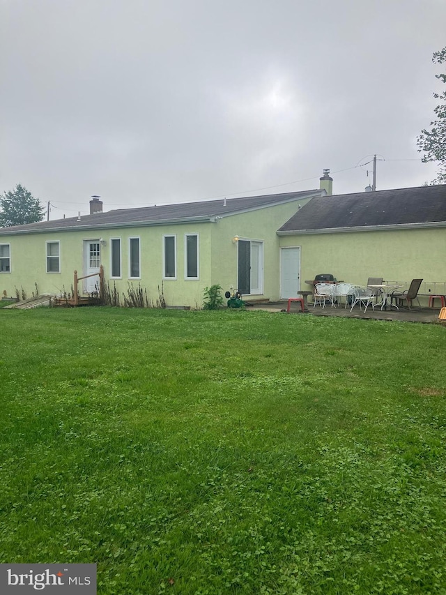 1336 Moyer Rd, Hatfield, PA 19440 - rear view of house with a yard, stucco siding, and a chimney