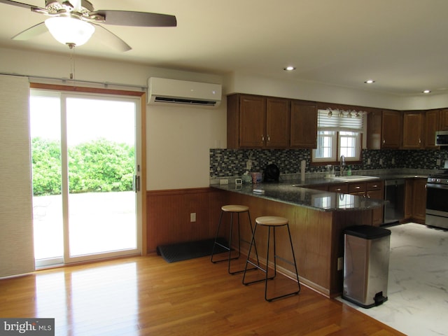 3590 Choptank Rd, Preston, MD 21655 - kitchen with an AC wall unit, stainless steel appliances, a peninsula, a kitchen breakfast bar, and tasteful backsplash