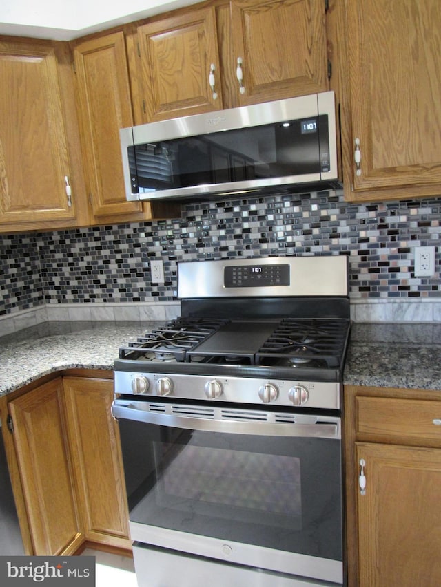 3590 Choptank Rd, Preston, MD 21655 - kitchen featuring appliances with stainless steel finishes, tasteful backsplash, brown cabinetry, and stone countertops