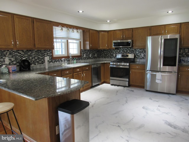 3590 Choptank Rd, Preston, MD 21655 - kitchen featuring appliances with stainless steel finishes, light marble finish floors, a peninsula, brown cabinetry, and decorative backsplash