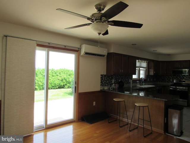 3590 Choptank Rd, Preston, MD 21655 - kitchen with range, a wall mounted air conditioner, a peninsula, and backsplash