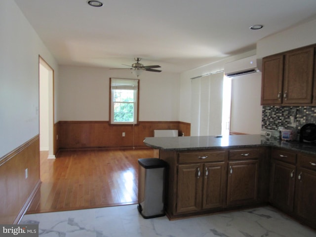 3590 Choptank Rd, Preston, MD 21655 - kitchen featuring a wainscoted wall, an AC wall unit, light marble finish flooring, wood walls, and a peninsula