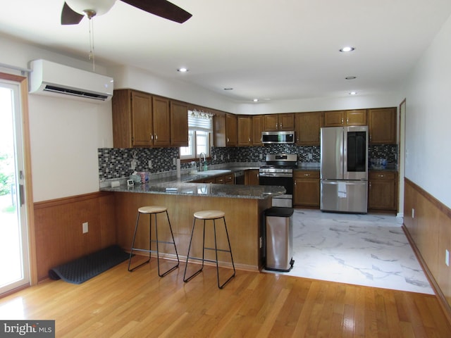 3590 Choptank Rd, Preston, MD 21655 - kitchen with stainless steel appliances, an AC wall unit, a peninsula, light wood-type flooring, and wainscoting