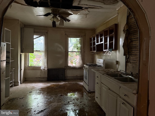 1031 N Ashburton St, Baltimore, MD 21216 - kitchen with gas range gas stove, ceiling fan, radiator heating unit, open shelves, and white cabinets