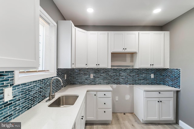 1955 N Collington Ave, Baltimore, MD 21213 - kitchen with light wood-type flooring, white cabinets, backsplash, light countertops, and recessed lighting