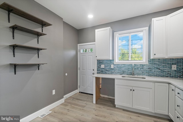 1955 N Collington Ave, Baltimore, MD 21213 - kitchen featuring light wood finished floors, backsplash, white cabinetry, light countertops, and open shelves