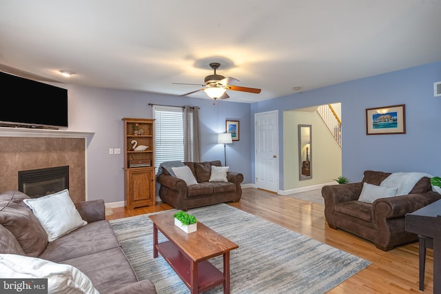1905 Reading Blvd, Reading, PA 19609 - living room featuring light wood finished floors, a ceiling fan, a fireplace, and stairway