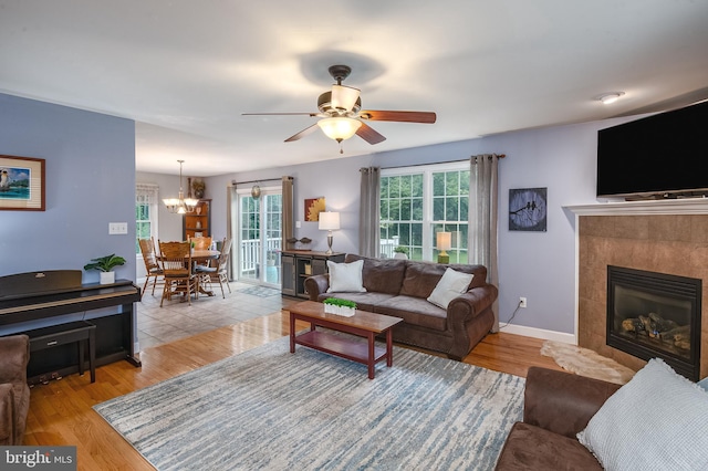 1905 Reading Blvd, Reading, PA 19609 - living room with a chandelier, a ceiling fan, a tiled fireplace, and light wood-style flooring