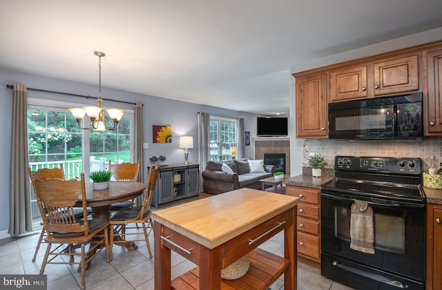 1905 Reading Blvd, Reading, PA 19609 - kitchen with black appliances, brown cabinetry, backsplash, light tile patterned floors, and a chandelier