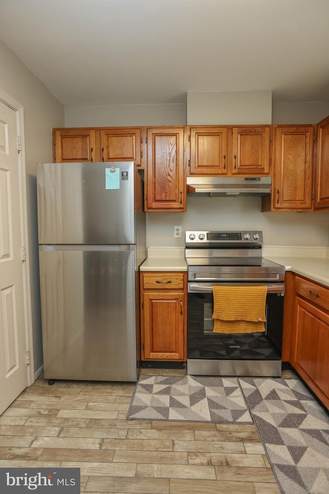 11 Bryce Ct, Baltimore, MD 21236 - kitchen with stainless steel appliances, under cabinet range hood, light countertops, and brown cabinets
