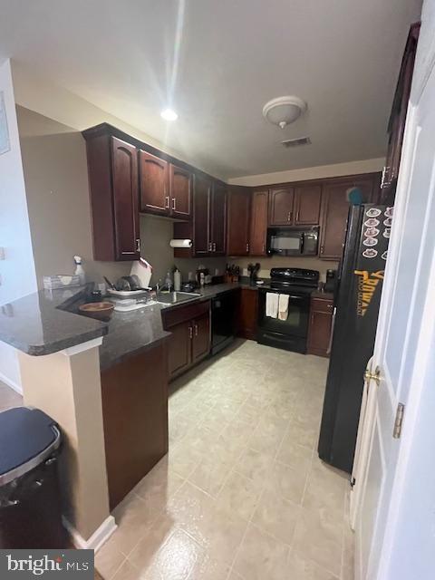 103 Raphael Ct, Williamstown, NJ 08094 - kitchen featuring black appliances, a peninsula, dark countertops, dark brown cabinetry, and a breakfast bar area