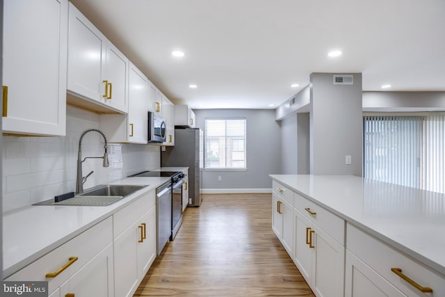 9704 Kingsbridge Dr Unit 203, Fairfax, VA 22031 - kitchen with stainless steel appliances, light wood-style floors, light countertops, white cabinetry, and recessed lighting