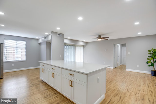 9704 Kingsbridge Dr Unit 203, Fairfax, VA 22031 - kitchen featuring ceiling fan, light wood-type flooring, light countertops, a center island, and white cabinetry