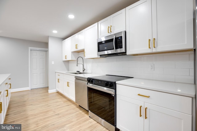 9704 Kingsbridge Dr Unit 203, Fairfax, VA 22031 - kitchen featuring appliances with stainless steel finishes, tasteful backsplash, light wood-type flooring, light countertops, and recessed lighting