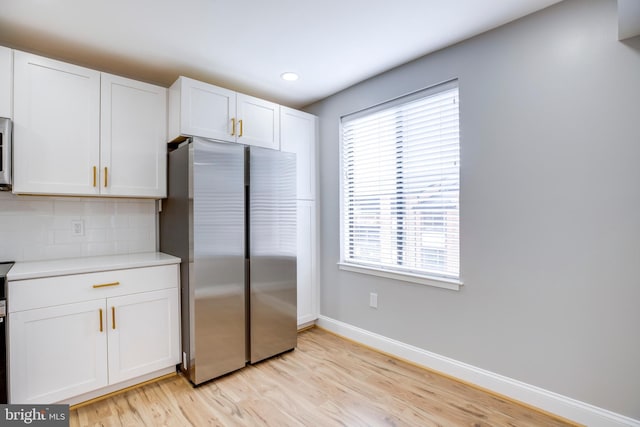 9704 Kingsbridge Dr Unit 203, Fairfax, VA 22031 - kitchen with freestanding refrigerator, white cabinets, light countertops, light wood-type flooring, and tasteful backsplash
