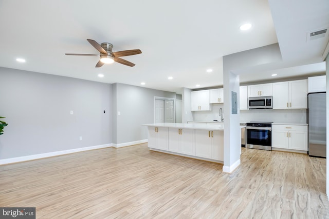 9704 Kingsbridge Dr Unit 203, Fairfax, VA 22031 - kitchen featuring appliances with stainless steel finishes, light countertops, light wood finished floors, recessed lighting, and white cabinetry