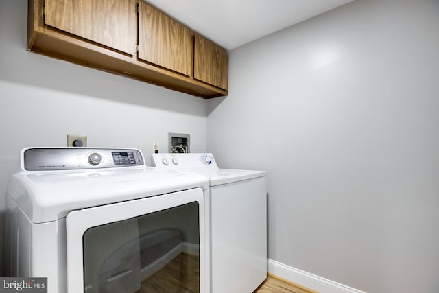 9704 Kingsbridge Dr Unit 203, Fairfax, VA 22031 - washroom featuring cabinet space, washer and dryer, and light wood-type flooring