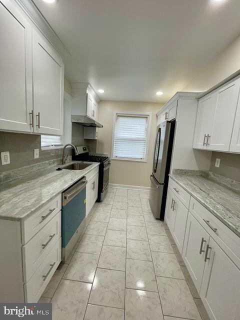 2301 Wyngate Rd, Suitland, MD 20746 - kitchen with appliances with stainless steel finishes, white cabinets, light stone counters, recessed lighting, and light marble finish flooring