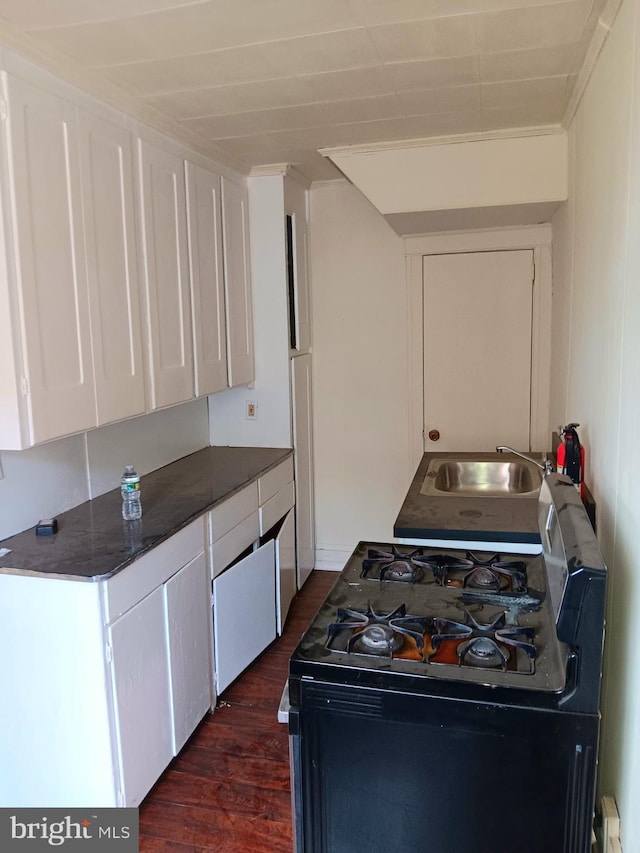 201 N 7th St, Darby, PA 19023 - kitchen with black range with gas cooktop, white cabinets, dark wood-style flooring, and dark countertops