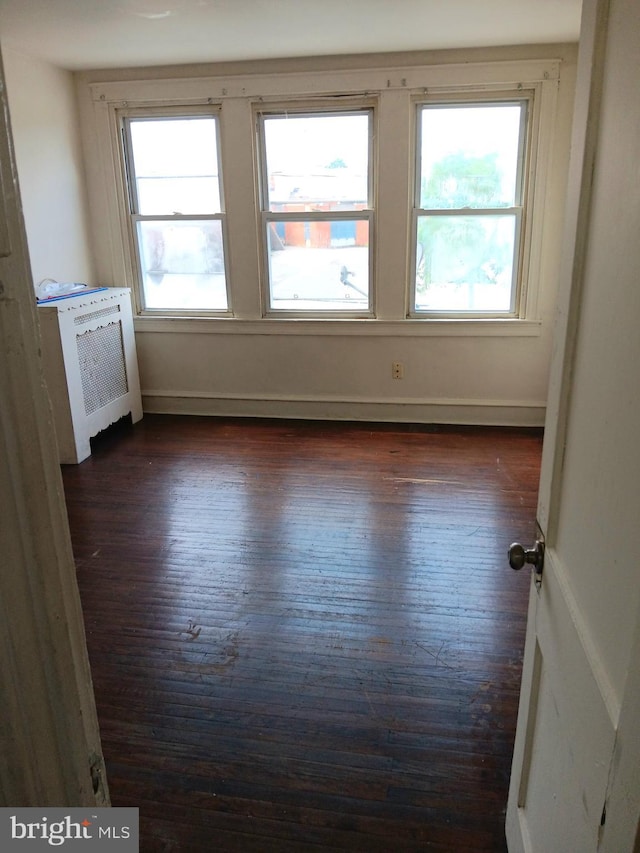 201 N 7th St, Darby, PA 19023 - empty room with radiator heating unit and dark wood-style flooring