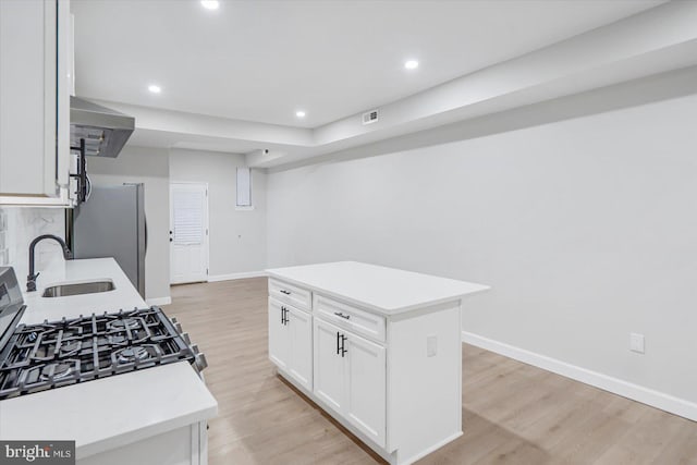 1635 Montpelier St, Baltimore, MD 21218 - kitchen with wall chimney range hood, light wood finished floors, light countertops, white cabinets, and recessed lighting