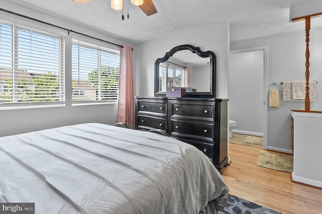 9258 Pirates Cv, Columbia, MD 21046 - bedroom with wood finished floors, ensuite bathroom, a textured ceiling, and a ceiling fan