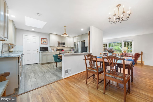 8306 Winslow Ave, Springfield, VA 22152 - dining room featuring light wood-style floors, a skylight, recessed lighting, and a chandelier