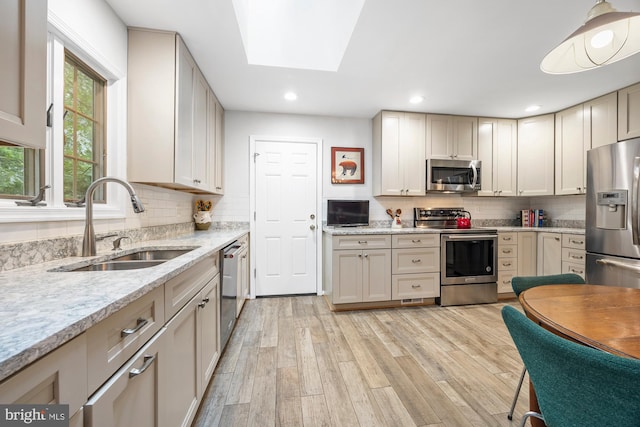 8306 Winslow Ave, Springfield, VA 22152 - kitchen with stainless steel appliances, light wood-style flooring, tasteful backsplash, a skylight, and recessed lighting