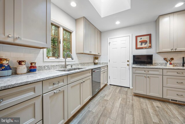 8306 Winslow Ave, Springfield, VA 22152 - kitchen featuring stainless steel dishwasher, tasteful backsplash, light wood-style floors, a skylight, and recessed lighting