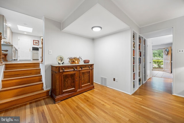 8306 Winslow Ave, Springfield, VA 22152 - corridor featuring light wood finished floors, a skylight, stairs, and built in shelves