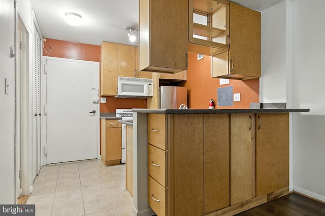 2030 F St NW Unit 111, Washington, DC 20006 - kitchen with white appliances, a peninsula, light tile patterned floors, glass insert cabinets, and dark countertops