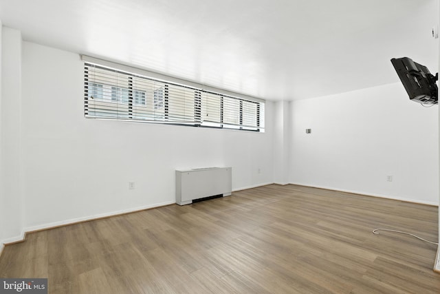 2030 F St NW Unit 111, Washington, DC 20006 - spare room featuring wood finished floors and radiator