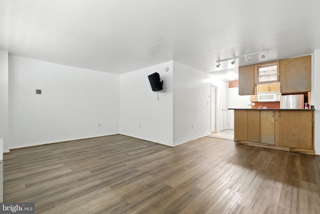 2030 F St NW Unit 111, Washington, DC 20006 - unfurnished living room featuring wood finished floors and rail lighting
