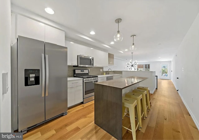 2538 W Girard Ave Unit A, Philadelphia, PA 19130 - kitchen featuring appliances with stainless steel finishes, a kitchen island, white cabinetry, a kitchen bar, and recessed lighting