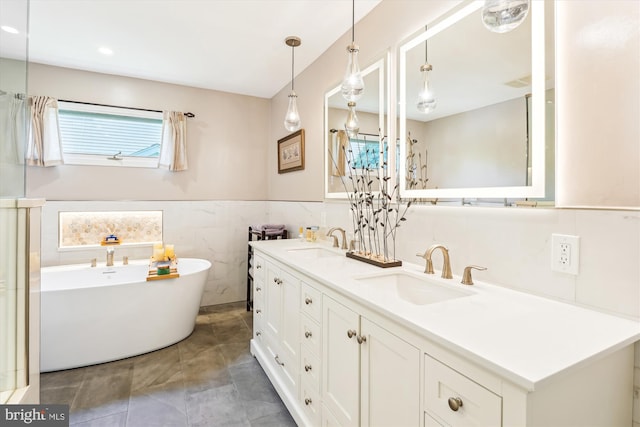 9505 Columbia Blvd, Silver Spring, MD 20910 - bathroom with a soaking tub, double vanity, wainscoting, tile walls, and tile patterned flooring