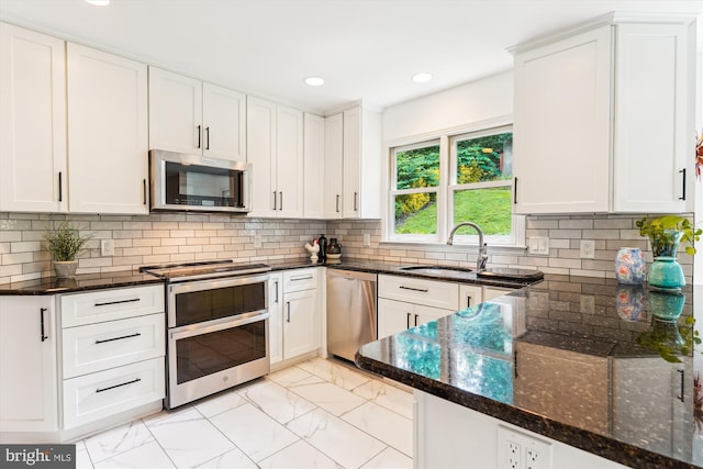 9505 Columbia Blvd, Silver Spring, MD 20910 - kitchen with stainless steel appliances, light marble finish floors, white cabinetry, dark stone counters, and recessed lighting